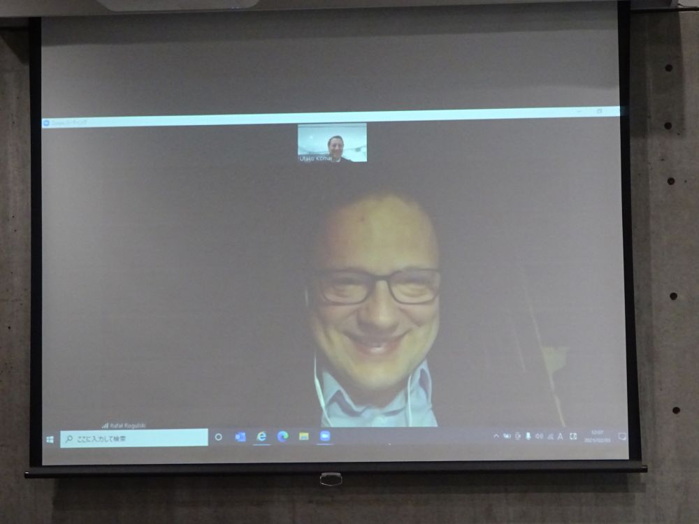 Pull down projector screen. Displayed on it, Rafał Rogulski, ENRS Director, smiles. He is videoconferencing with one other man.