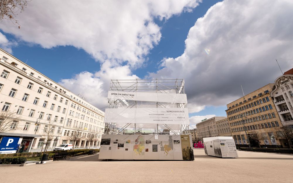 Freedom Square in Poznań. Cube-like installation of After the Great War exhibition stands in the center of the empty square. The blue sky with few large white clouds above it.
