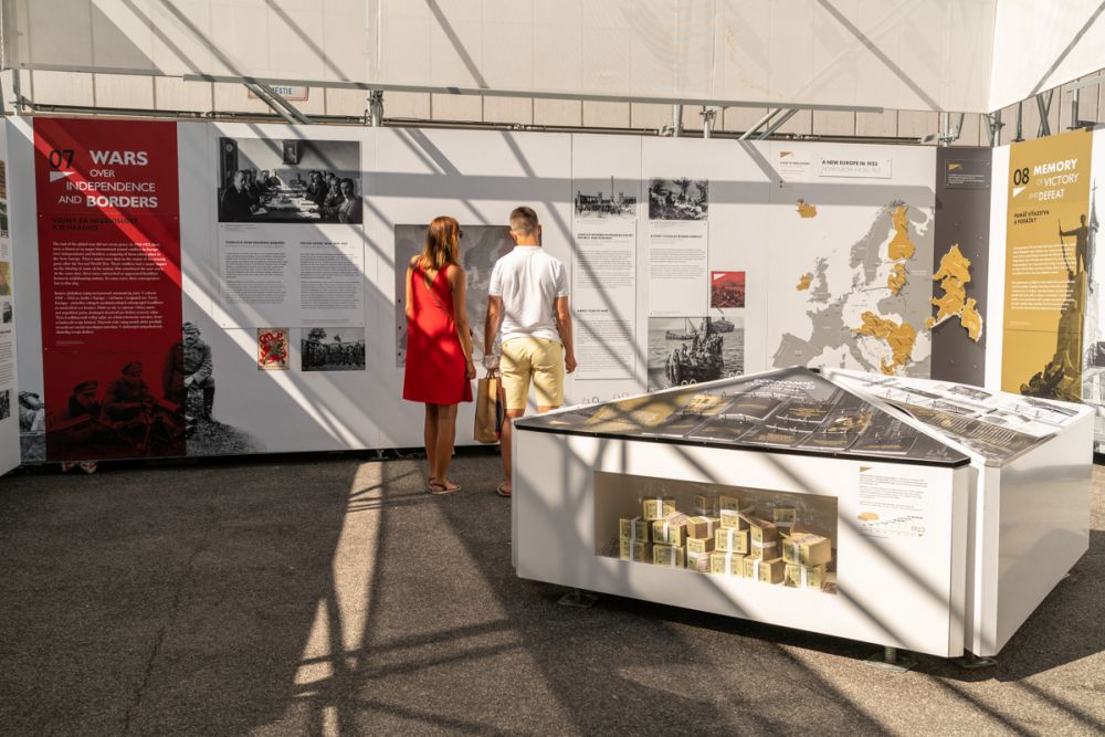 Interior of the installation of After the Great War exhibition. A man and a woman look at the infographic on the inner wall of the exhibition. The panels that they inspect are focused on shifting borders in interwar Europe.