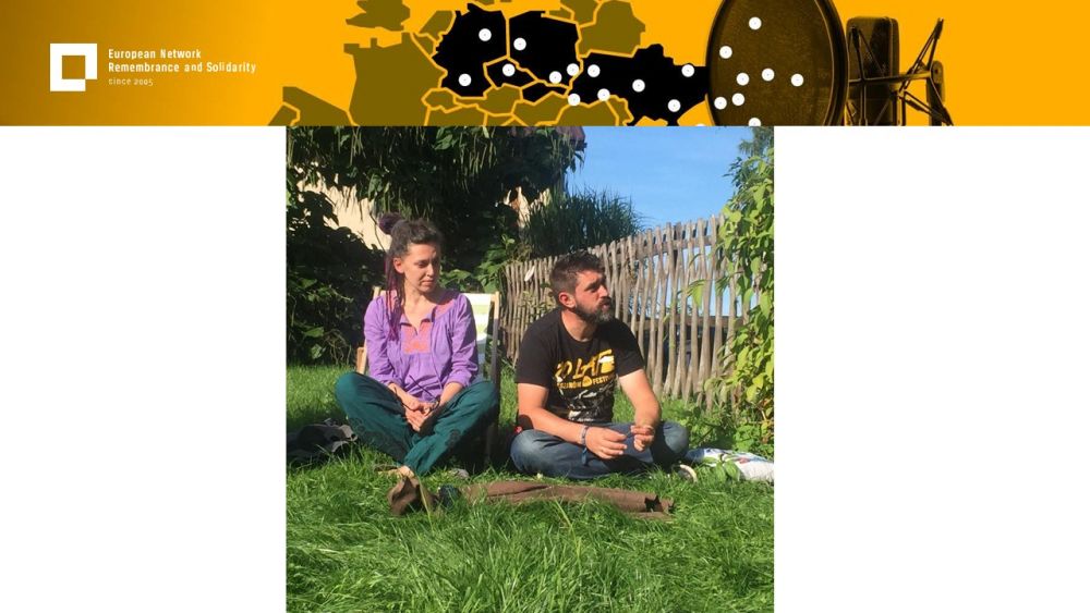 Presentation slide with a single photo in the center. It presents two people, a woman and a man, sitting on a grass lawn on a sunny day. Above all of it, a gold-yellow header with European Network remembrance and Solidarity.