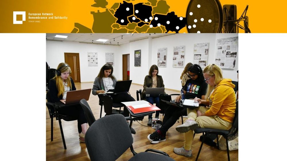 Presentation slide with a single photo in the center. It presents a group of six young people sitting in a circle of chairs. They are working on their laptops in focus. Above all of it, a gold-yellow header with European Network remembrance and Solidarity